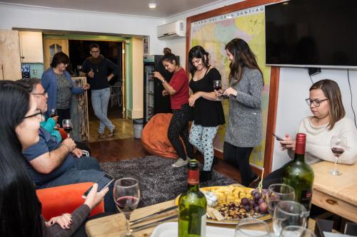 a group of people sitting around a table with wine glasses at Hostal Casa Aborigen in Santiago