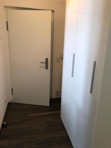 a white door in a room with a wooden floor at Citybergblick in Innsbruck