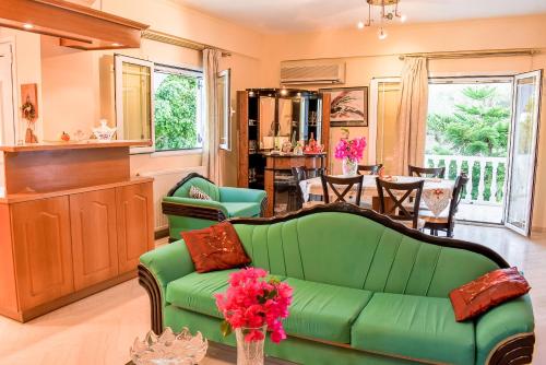 a living room with a green couch and a table at Vicky's Village private House in Fiolítis