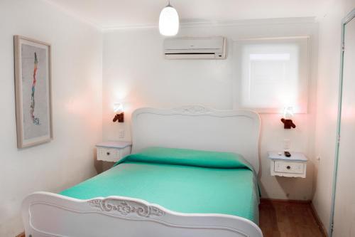 a small bedroom with a white bed in a room at Hostal Casa Aborigen in Santiago