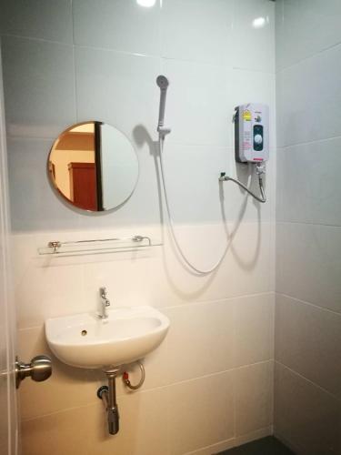 a bathroom with a shower and a sink and a mirror at Duangdren Apartment in Chiang Mai