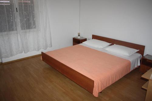 a bedroom with a large bed with a wooden headboard at Sobe Stipe in Primošten