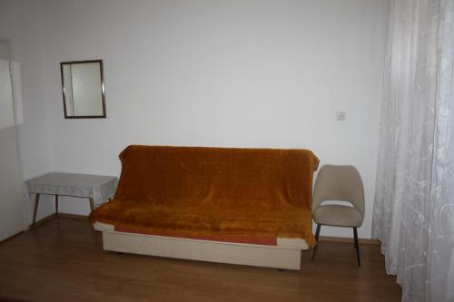 a bed with a blanket and a chair in a room at Sobe Stipe in Primošten