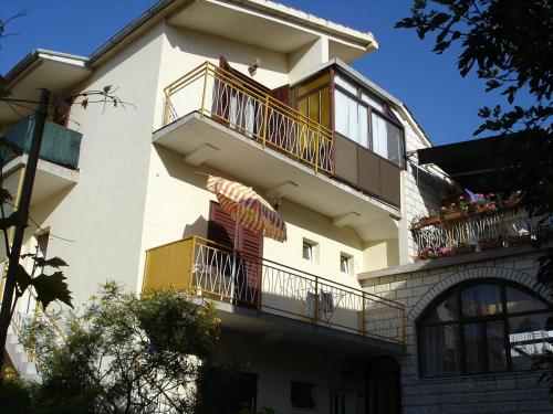 a large white building with balconies and windows at Sobe Stipe in Primošten