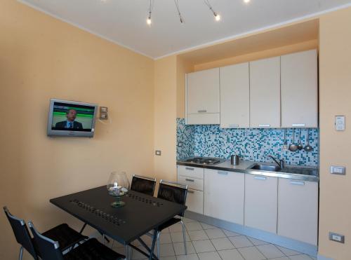 a kitchen with a table and a tv on the wall at Residence Le Dune Club in Varigotti