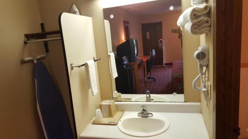 a bathroom with a sink and a mirror at Scottish Inn Knoxville in Knoxville