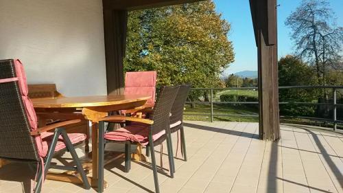 Une table et des chaises en bois sont disponibles sur la terrasse. dans l'établissement Ferienhaus Westerbuchberg, à Übersee