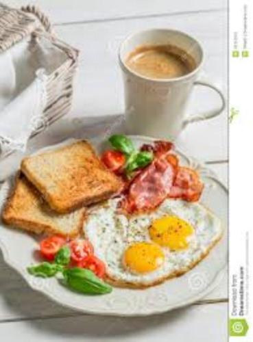 um prato de ovos e torradas com uma chávena de café em Nile Star Suites &Apartment em Cairo