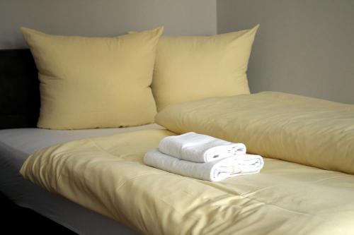 a bed with two towels sitting on top of it at Apartments anno 1560 in Quedlinburg