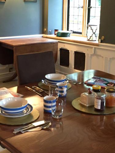 a wooden table with plates and utensils on it at The Grange in North Cadbury