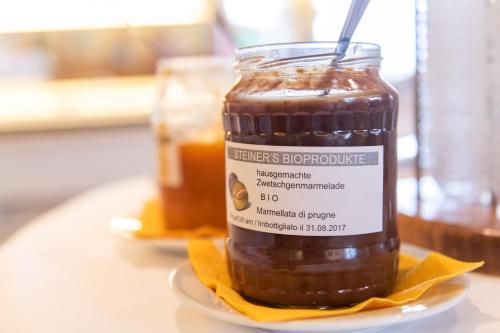 a jar of honey on a plate on a table at Bio Hotel Panorama in Malles Venosta