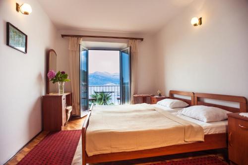 a bedroom with a bed and a large window at Pansion Tereza in Lopud Island