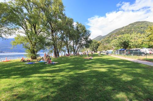 a group of people laying on the grass in a park at The Camp by Maggiore Suites in Maccagno Inferiore