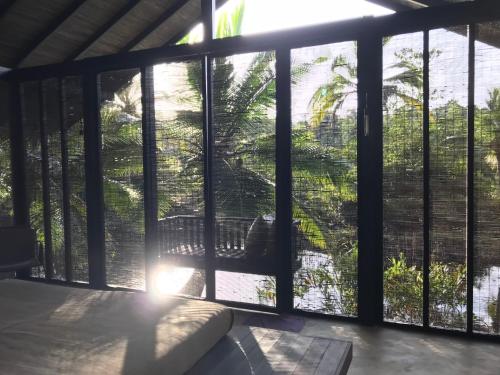 a room with a large glass window with a bed at KAJU GREEN eco lodges in Unawatuna