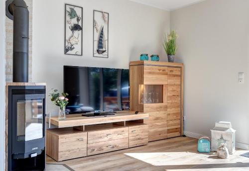 uma sala de estar com uma televisão de ecrã plano num centro de entretenimento em madeira em Haus Sternstunden em Bansin