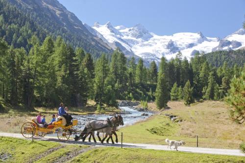 a group of people riding in a horse drawn carriage at Schloss Hotel & Spa Pontresina in Pontresina