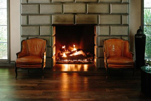 two chairs in a living room with a fireplace at Hotel Yountville in Yountville
