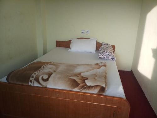 un letto con struttura in legno e coperta di Gorgeous Village Guest House a Pokhara
