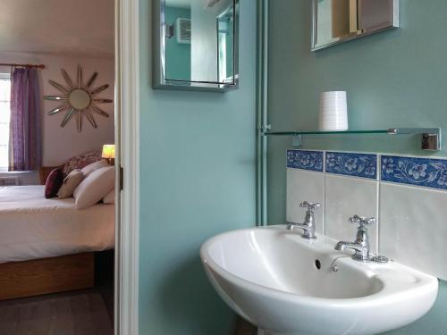 a bathroom with a sink and a bed and a mirror at 4 Bell Lodge, Thorpeness in Thorpeness