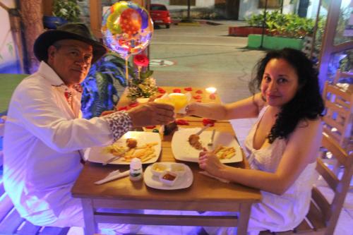 a man and woman sitting at a table eating food at Eco Hotel El Refugio Boutique in Leticia