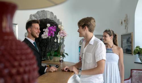 a man and a woman standing at a table at Villa Corallium in Praiano