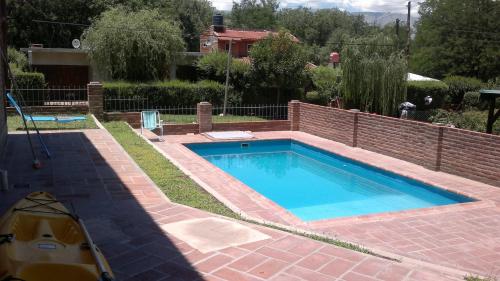 a swimming pool in a yard with a brick wall at Las Acacias in Nono