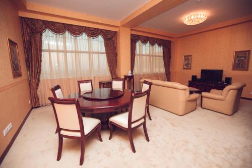 a living room with a dining room table and chairs at Ramada Plaza by Wyndham Gence in Ganja