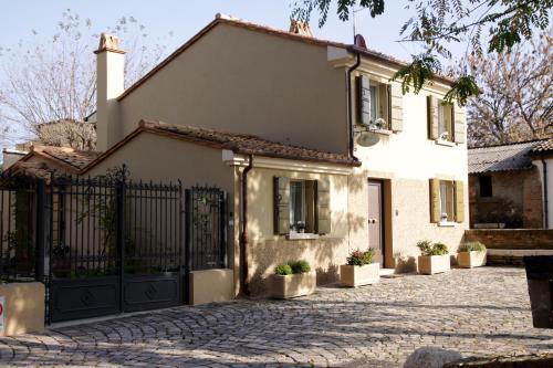 a white house with a black gate and a driveway at Casina Le Conserve in Cesenatico