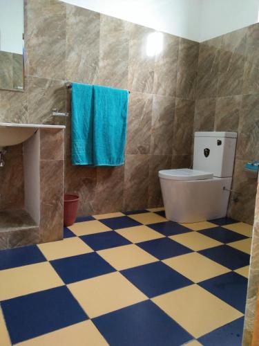 a bathroom with a toilet and a checkered floor at Old Town Hotel in Kandy