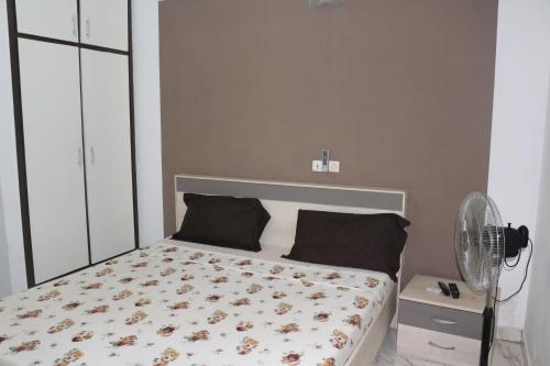 Un dormitorio con una cama y un ventilador. en Happy Welcome Bietry 2, en Abiyán
