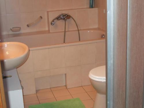 a bathroom with a sink and a tub and a toilet at Villa Anita in Kraljevica