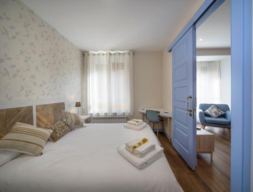 a bedroom with a large bed with a blue door at Casa Manuela in Astorga