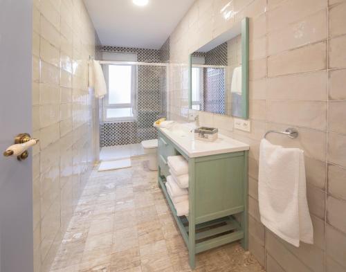 a bathroom with a sink and a toilet and a mirror at Casa Manuela in Astorga