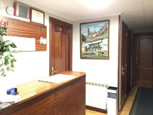 ein Büro mit einem Schreibtisch und einem Gemälde an der Wand in der Unterkunft Hostal Hilton in Burgos