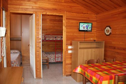 Dormitorio con cama y TV en una cabina en Caravelle Camping Village, en Ceriale