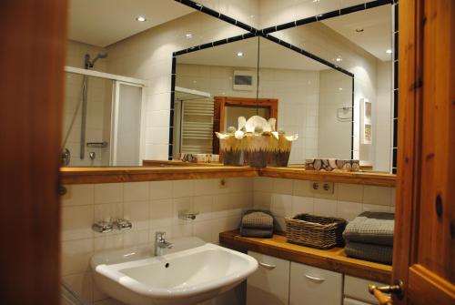 een badkamer met een wastafel en een grote spiegel bij Inselresidenz Wattenmeer - Wohnung 7 in Juist