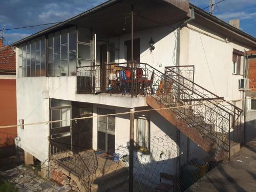 a white building with a staircase leading to a balcony at Iliovski Inn - Just Like Home in Prilep