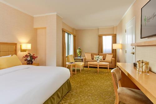 サンフランシスコにあるオーチャード ガーデン ホテルのベッドとリビングルームが備わるホテルルームです。