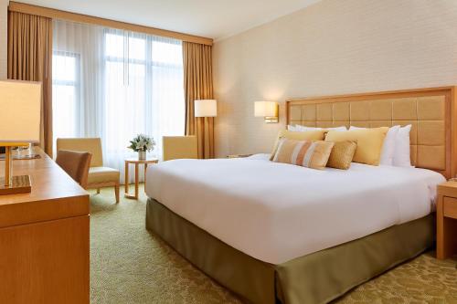 Een bed of bedden in een kamer bij Orchard Garden Hotel