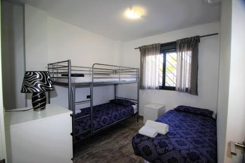 a bedroom with two bunk beds and a window at Oasis Beach Sonia in Orihuela Costa