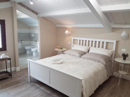 a white bedroom with a large bed and a bathroom at White House in Cagliari