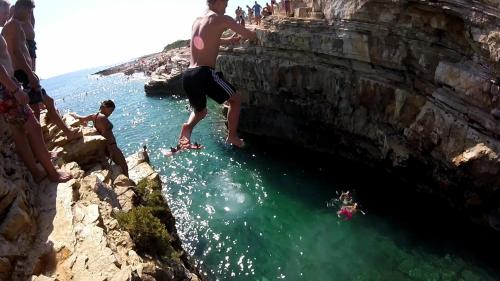 a man standing on the side of a cliff in the water at Villa Natalija in Medulin