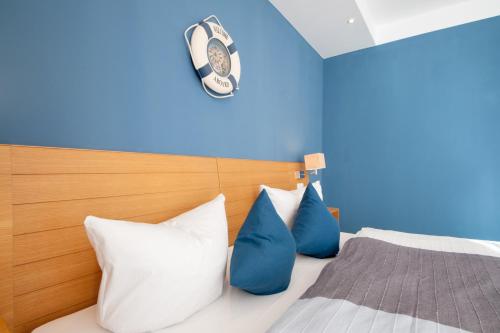 a bedroom with a bed with blue and white pillows at Inselquartett - Fewo Hiddensee in Wiek auf Rügen 