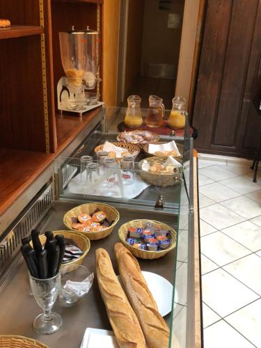 - un buffet avec du pain et d'autres aliments sur un comptoir dans l'établissement Hotel Les Arceaux, à Saint-Sever