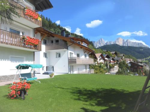 a green lawn in front of a building at Garni B&B Apartments Plank in Nova Levante