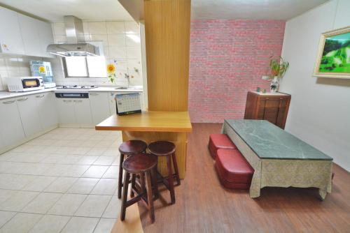 a kitchen with a counter and a table and stools at 博愛泊旅讀心境 in Hualien City