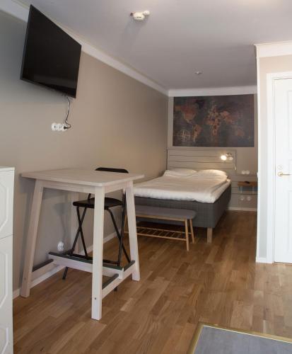 a room with a bed and a table with a tv at Södra Hotellet in Norrköping