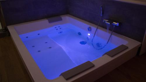 eine Badewanne mit blauem Licht im Bad in der Unterkunft Ker spa, gite avec spa privatif dans la chambre in Dol-de-Bretagne