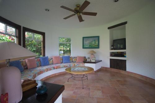 a living room with a couch and a ceiling fan at Villa Coiros Bici, Hospedaje y Bienestar in Tonatico