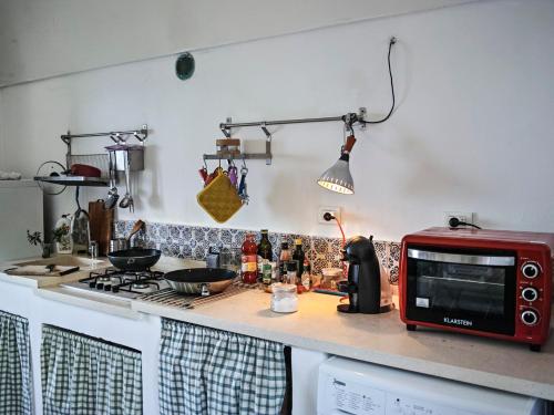 a kitchen with a counter top with a red microwave at Dammuso sulla scogliera - Pantelleria in Scauri